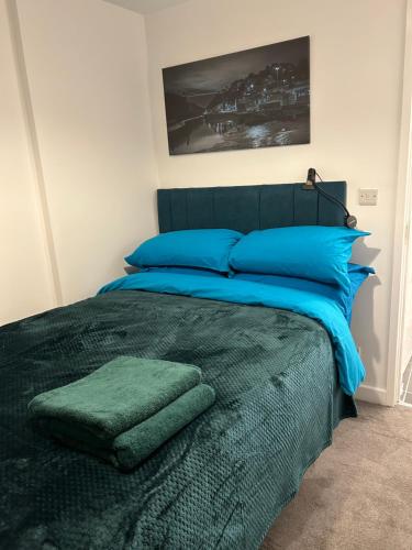 a bedroom with a large bed with blue pillows at The Grove En-Suite Rooms in Bristol