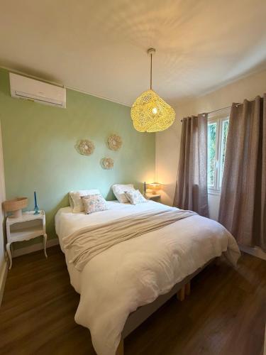 a bedroom with a large bed and a chandelier at Villa San Michele 3 chambres in Linguizzetta