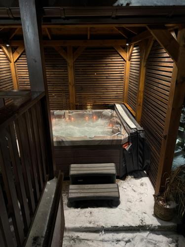 an outdoor hot tub in a house with snow on the ground at Modern Village in Nowinka