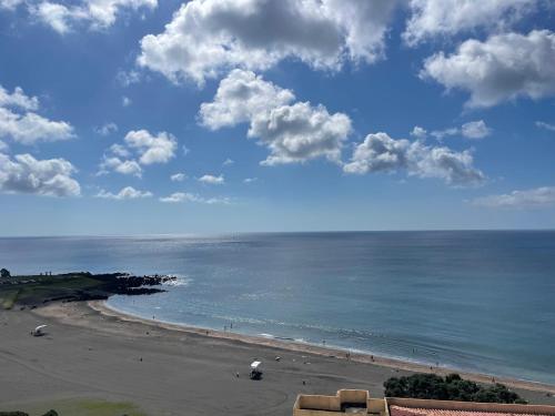 a view of a beach with people on the sand at Pópulo Mar in Ponta Delgada