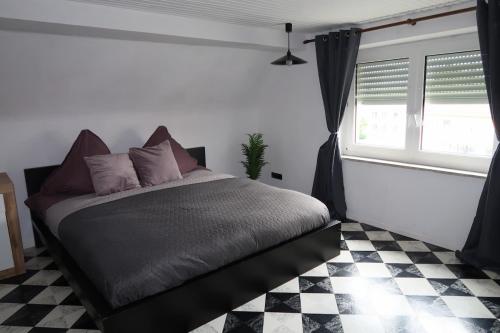 a bedroom with a bed and a checkered floor at Cozy room with bathroom in a private house in Bergrheinfeld