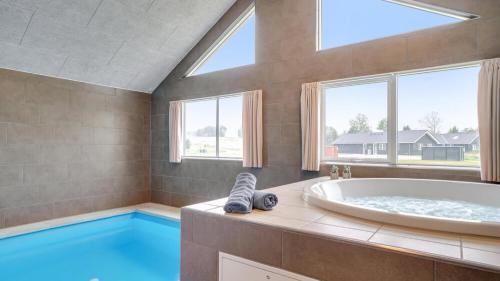 a large bathroom with a tub and a large window at Villavilla 474 - Grenå Strand, Østjylland in Grenå