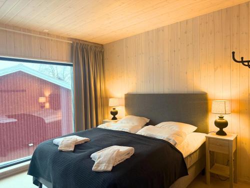 a bedroom with a bed with two towels on it at Alpine Townhouse - Åre Valley Lodges in Åre