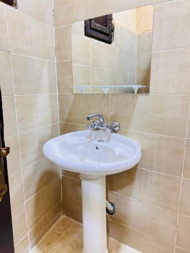 a bathroom with a white sink in a room at لودج ادرار احكيك in Siwa