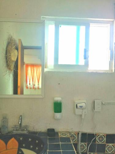 a bathroom with a sink and a mirror and a window at Hermosa Casa Colibri in Oaxtepec