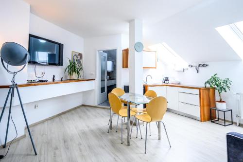 a kitchen and dining room with a table and chairs at The LOFT Apartments Ljubljana in Ljubljana