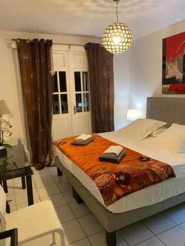 a bedroom with a bed with two towels on it at Lauris - Résidence Savannah, 1 ou 2 Chambres avec cuve in Saint-François