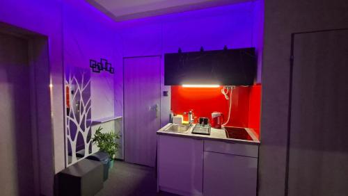 a kitchen with purple and red walls and a sink at Hortensja 309 in Koszalin