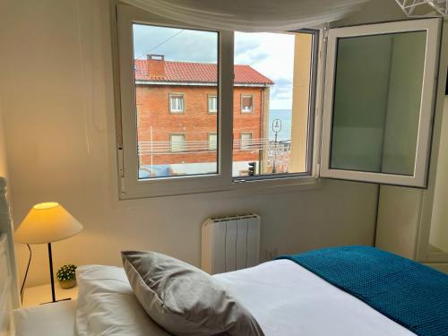 a bedroom with a large window and a bed at El Orbayín de Llastres in Lastres