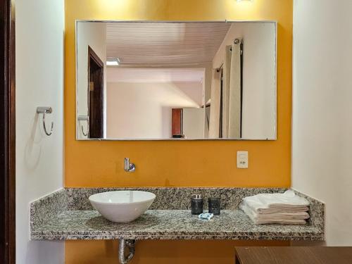 a bathroom with a sink and a large mirror at Pantanal Hotel in Miranda