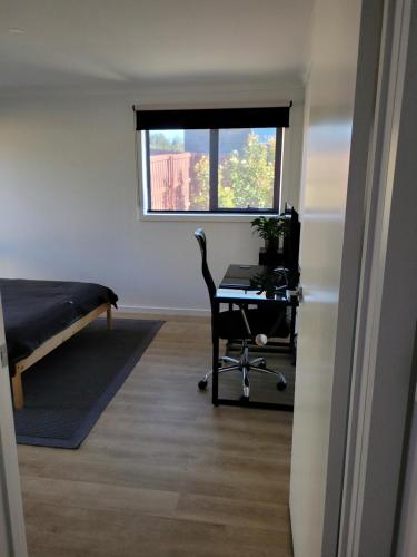 a room with a desk and a bed and a computer at Easy homestay for solo traveller in Rokeby