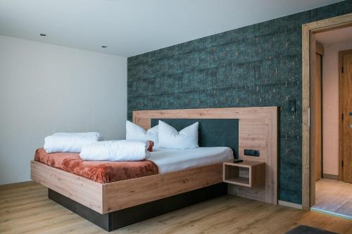 a bedroom with a bed with a green accent wall at die Harmonie in Nauders