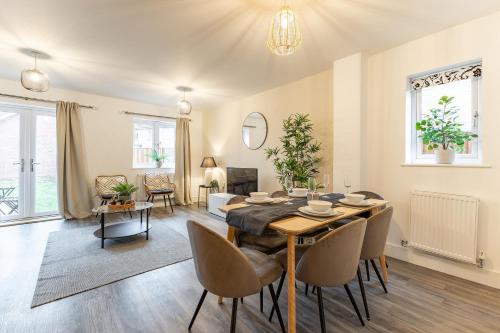 a dining room and living room with a table and chairs at Heathrow House with Parking - Sleeps 5 near M25, Virginia Water, Thorpe Park & Legoland, Mid To Long Term Bookings Welcome in Stanwell