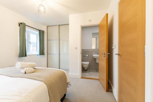 a bedroom with a bed and a bathroom with a toilet at Heathrow House with Parking - Sleeps 5 near M25, Virginia Water, Thorpe Park & Legoland, Mid To Long Term Bookings Welcome in Stanwell