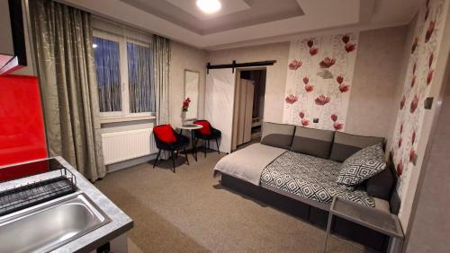 a small bedroom with a bed and a table at Hortensja 309 in Koszalin