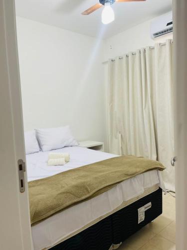a bedroom with a bed and a ceiling fan at Praia dos Corais apt 79 in Santa Cruz Cabrália