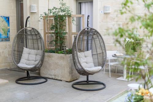two wicker chairs sitting on a patio at Palazzo Dei Dondoli in Lecce