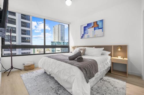a bedroom with a large bed and large windows at Downtown Miami - Rooftop Pool & Gym in Miami