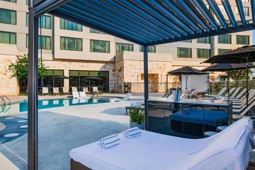 a large building with a swimming pool with a blue canopy at The Westin Dallas Southlake in Southlake