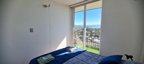 a bedroom with a bed and a large window at Vista Insuperable in Villarrica