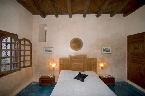 een slaapkamer met een bed met 2 nachtkastjes en 2 lampen bij Villa Oceane in Taghazout