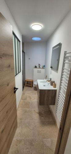 a bathroom with a sink and a toilet and a mirror at Le Donjon du Chateau in Tournissan