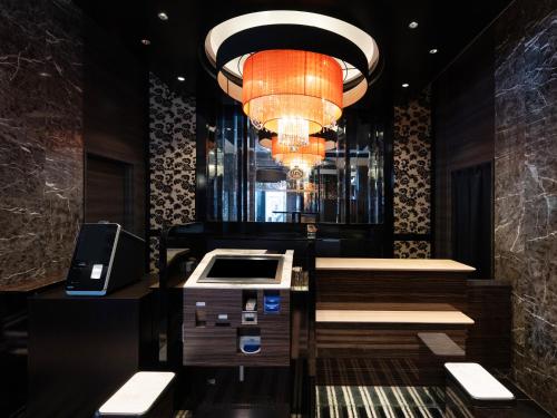 a lobby with a cash register and a chandelier at APA Hotel Higashi Shinjuku Kabukicho Higashi in Tokyo