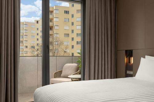 a bedroom with a bed and a window with a chair at Residence Inn by Marriott Antalya in Antalya