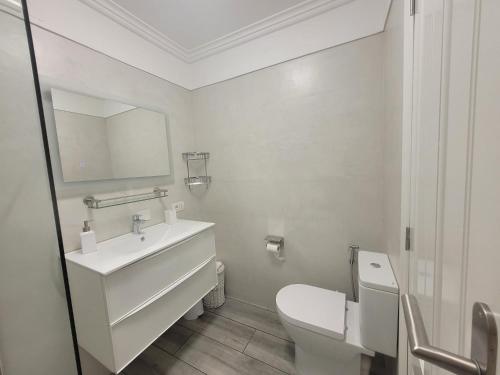 a white bathroom with a sink and a toilet at Lavilla1XO in Valverde
