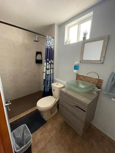 a bathroom with a toilet and a sink and a window at Sarah's Place San Andres in San Andrés
