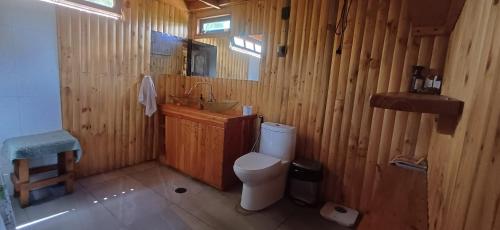 a wooden bathroom with a toilet and a sink at Hostal Arboretum cafeteria & jardin in Hijuelas