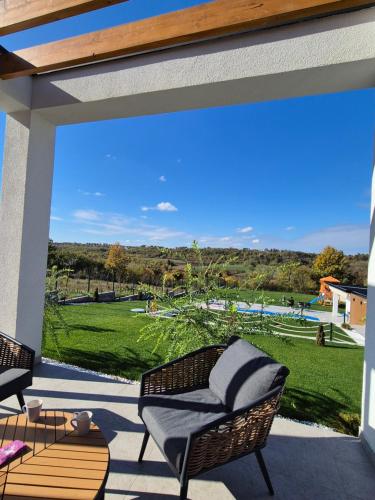 a patio with chairs and a view of a park at Casa Toleni in Ba°evac