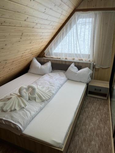 a couple of beds in a room with a window at Casa Ionuț și Sofia in Podu Dîmboviţei