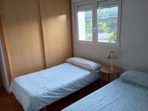 two twin beds in a room with a window at Chalet en Sieteiglesias, Sierra Norte de Madrid in Sieteiglesias