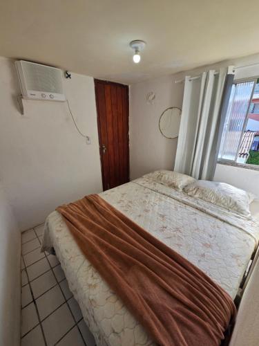 a bedroom with a bed and a window at Apto no centro com 3 quartos in Ilhéus