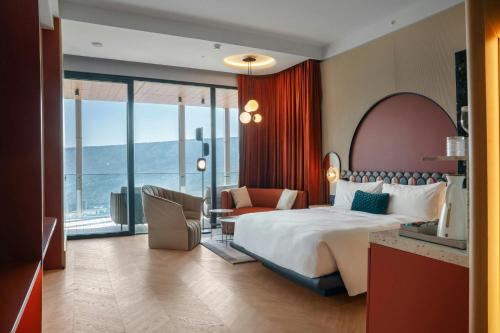 a hotel room with a large bed and a desk at Paragraph Golf & Spa Tabori, Autograph Collection in Tbilisi City