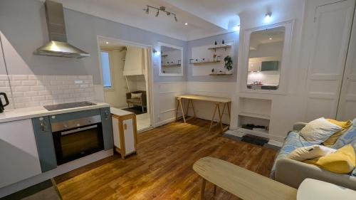 a living room with a couch and a kitchen at T2 - Plein Centre - 4 voyageurs - Jacuzzi ! in Bayonne