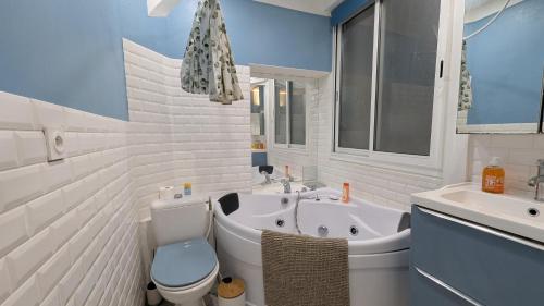 a bathroom with a toilet and a tub and a sink at T2 - Plein Centre - 4 voyageurs - Jacuzzi ! in Bayonne