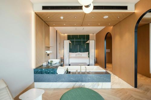 a bathroom with a tub and a bed at Paragraph Golf & Spa Tabori, Autograph Collection in Tbilisi City
