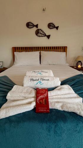 a bed with a pile of towels on it at Maré House in Amontada