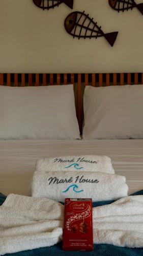 a pile of towels sitting on top of a bed at Maré House in Amontada