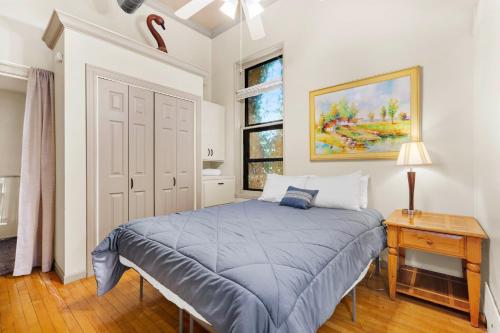 a bedroom with a blue bed and a window at Historic Loft w/ Private Deck, 2 Blocks to Dtwn in Saugatuck