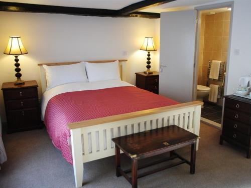 a bedroom with a large bed with a red blanket at The Blenheim Buttery in Woodstock