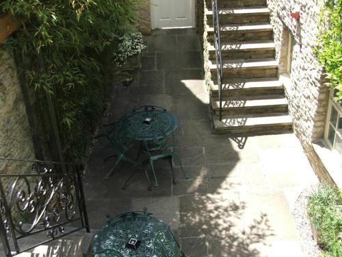 a patio with a table and chairs and stairs at The Blenheim Buttery in Woodstock