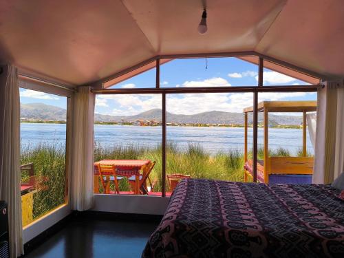 a bedroom with a bed and a view of the water at Uros Quechua`s Lodge Titicaca in Puno