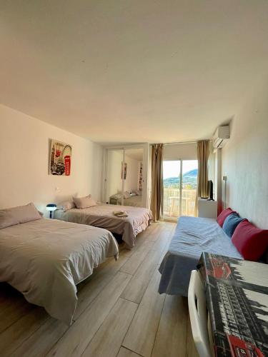 a hotel room with two beds and a window at Jupiter Sea View in Benalmádena