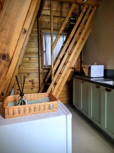 a kitchen with an attic with a wooden staircase at Hospedagem Chalés Prosas e Versos in Penha