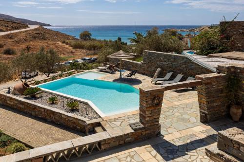 an outdoor swimming pool with a patio and the ocean at Relax Joy Villa | Koundouros Kea Beachside in Koundouros