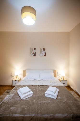 a bedroom with a large bed with two towels on it at Riverside Escape ,modern residence with courtyard in Florina