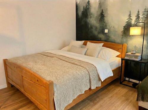 a bedroom with a bed with a painting on the wall at Wohlfühlapartment GUXHAGEN- nähe Bahnhof & A7, schnell in Kassel in Guxhagen